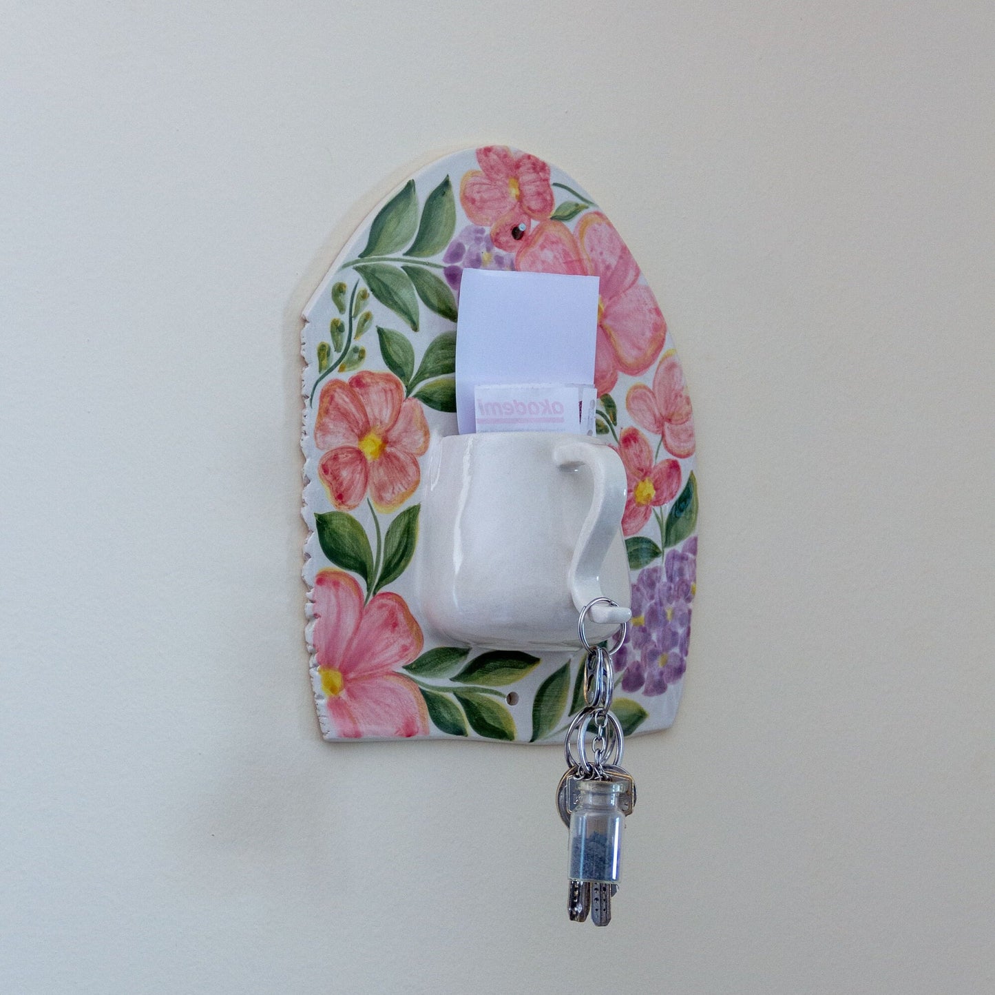 Floral wall art key holder displaying a set of keys and mail, perfect for home entrance decor. Blumige Wandkunst-Schlüsselhalter, die einen Schlüsselbund und Post anzeigen, perfekt für den Eingangsbereich-Dekor.