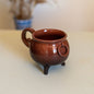 Cauldron Halloween mug, perfect for spooky season. This pottery mug features a unique cauldron design, ideal for enjoying your favorite hot beverages. A great addition to your Halloween decor and a perfect gift for witchcraft enthusiasts.