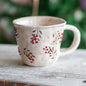 Handcrafted vintage Christmas pottery mug with intricate Kokina flower design.