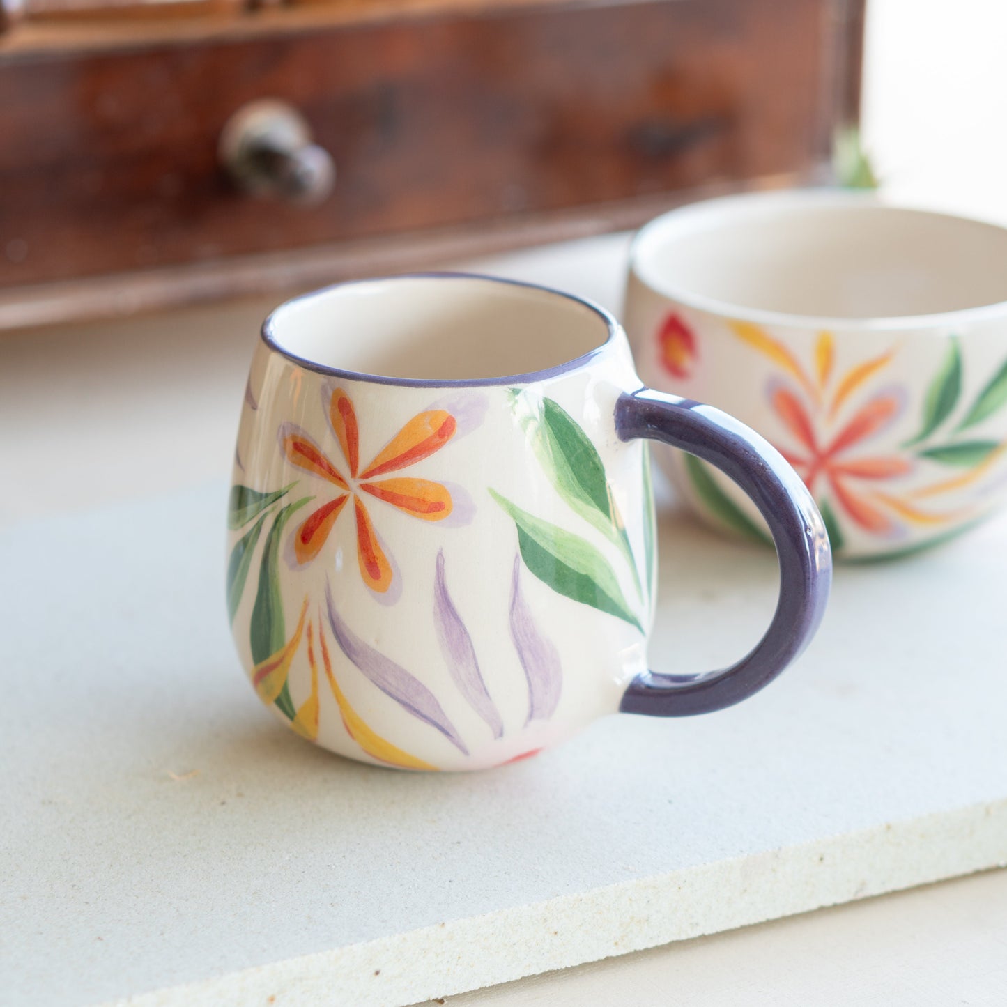 Side view of Blossom Mug with a focus on the purple-hued handle, illustrating the mug's robust and ergonomic design.