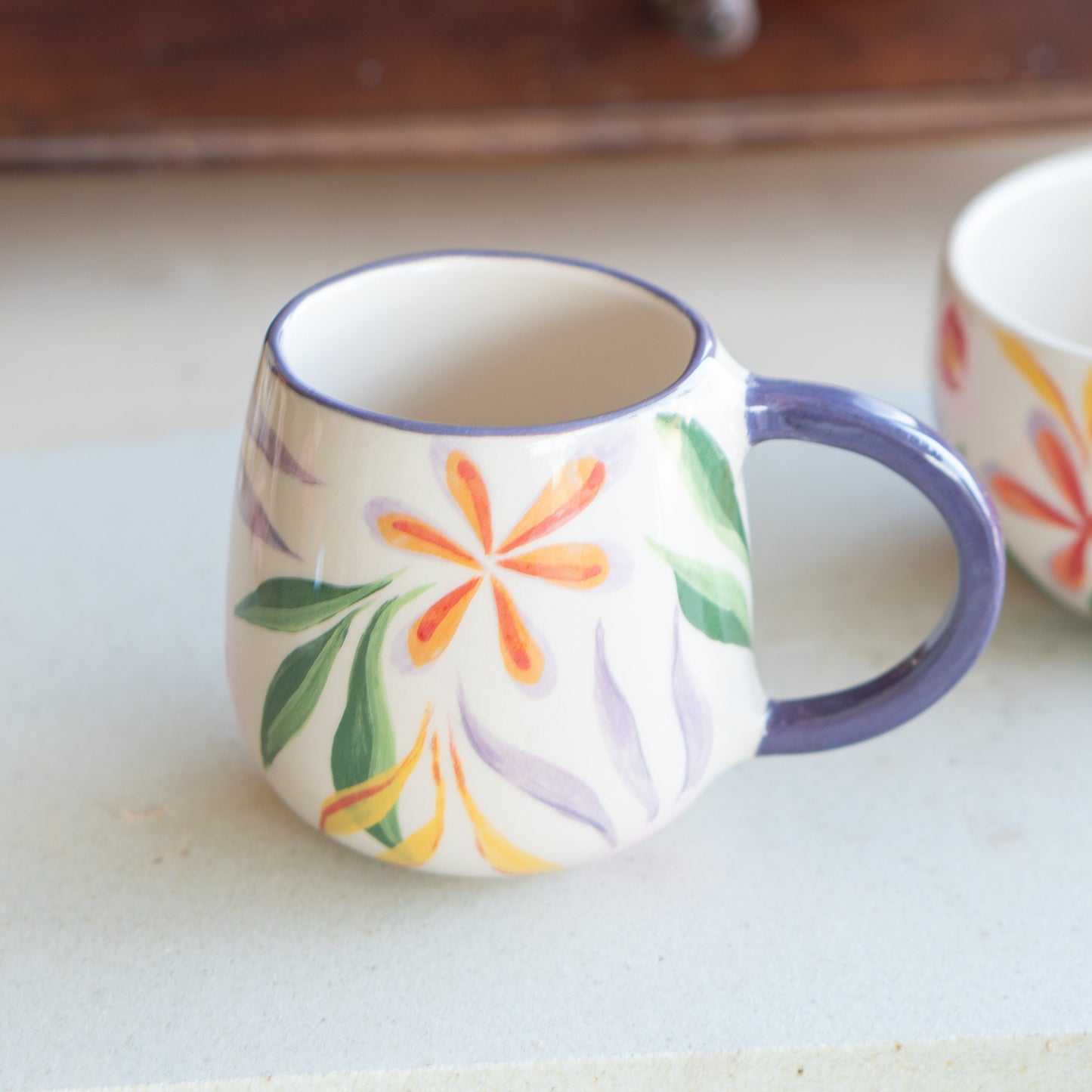 Blossom Mug angled to show the rich detail of its floral pattern, highlighted by natural light to emphasize the watercolor effect